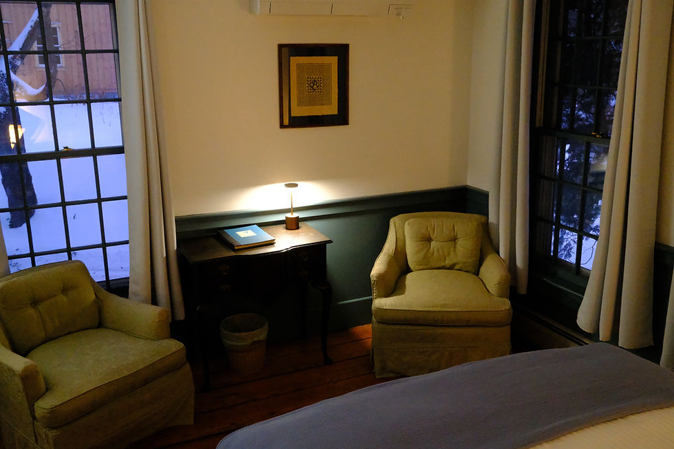 Two armchairs at the foot of the queen-sized bed in the 2-bedroom Susan Suite.