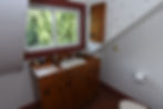 The Ilse bathroom has a wooden counter and sink below a window.