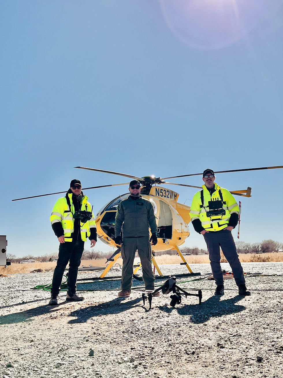 Drone pilot, heli pilot and aerial dp standing in front of Winco's helicopter