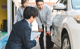 車の説明を受けている人たち