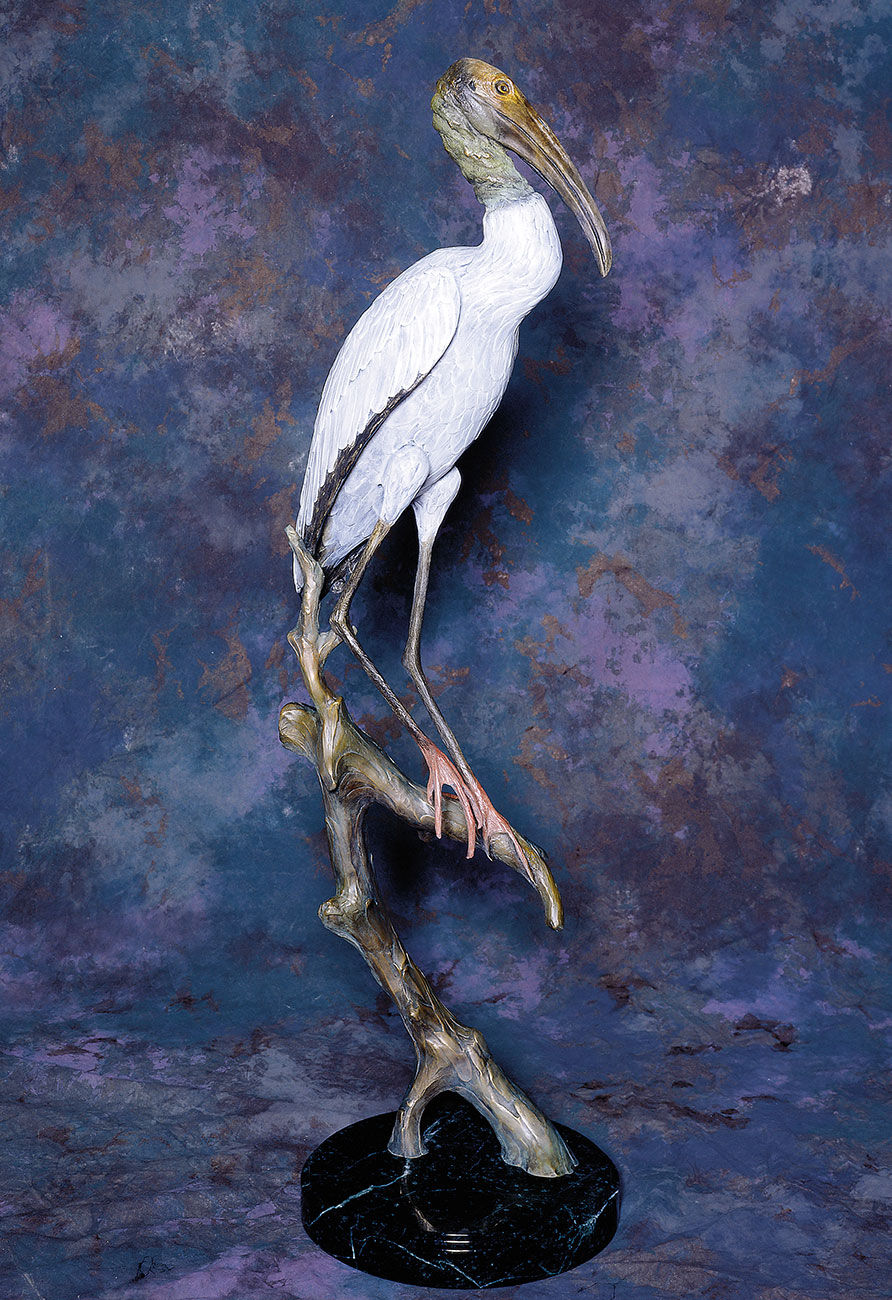 Thumbnail: Life-size bronze wood stork sculpture with realistic patina perched on a sculpted branch.