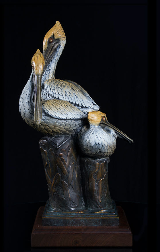 Thumbnail: bronze sculpture of three pelicans gathered together on a post.
