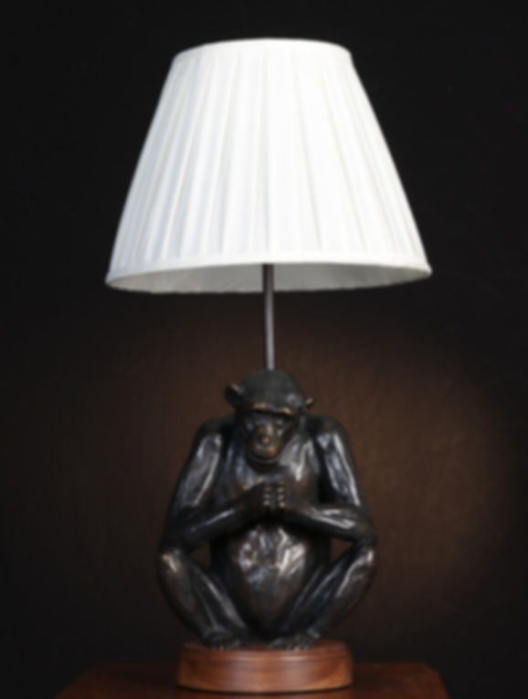 Bronze chimpanzee sculpture seated with hands clasped, designed as a table lamp