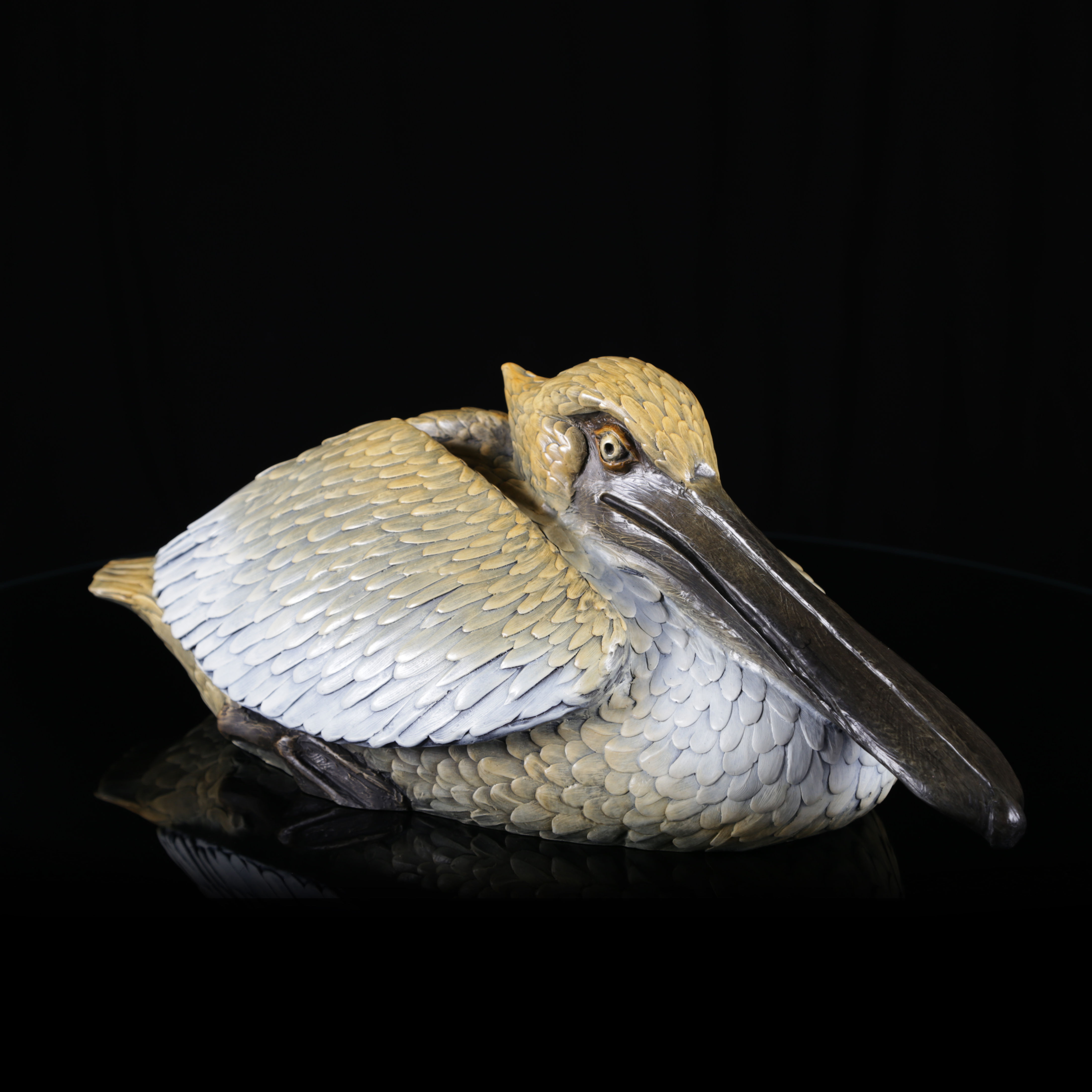 Tranquility by Geoffrey C. Smith — bronze pelican sculpture with wings tucked, capturing a calm moment of coastal peace.