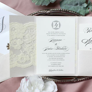 Classic wedding invitation suite in black with monogram at top in a lace wrapped enclosure trifold