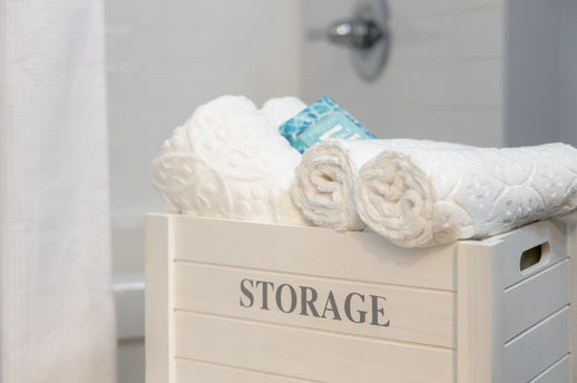 White storage crate labeled STORAGE with towels