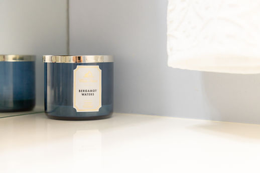 Blue 'BERGAMOT WATERS' candle on a white surface