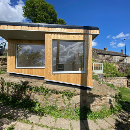 Artist's studio with Siberian larch cladding, colour coded aluminium windows and sedum green roof