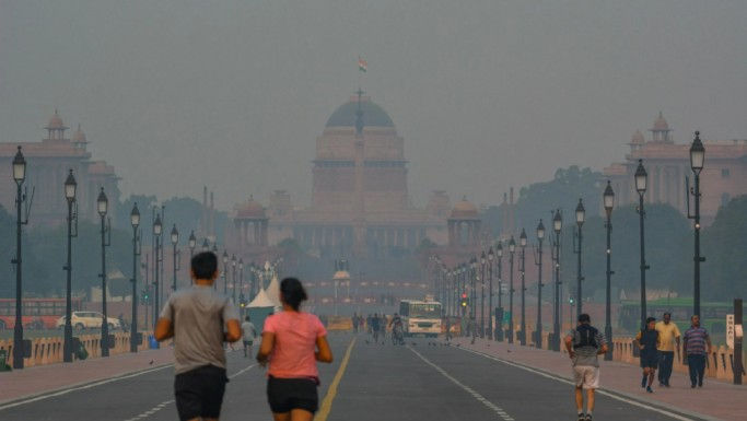 Smog covering Rashtrapati Bhavan the morning after Diwali, with vehicles moving slowly through reduced visibility.