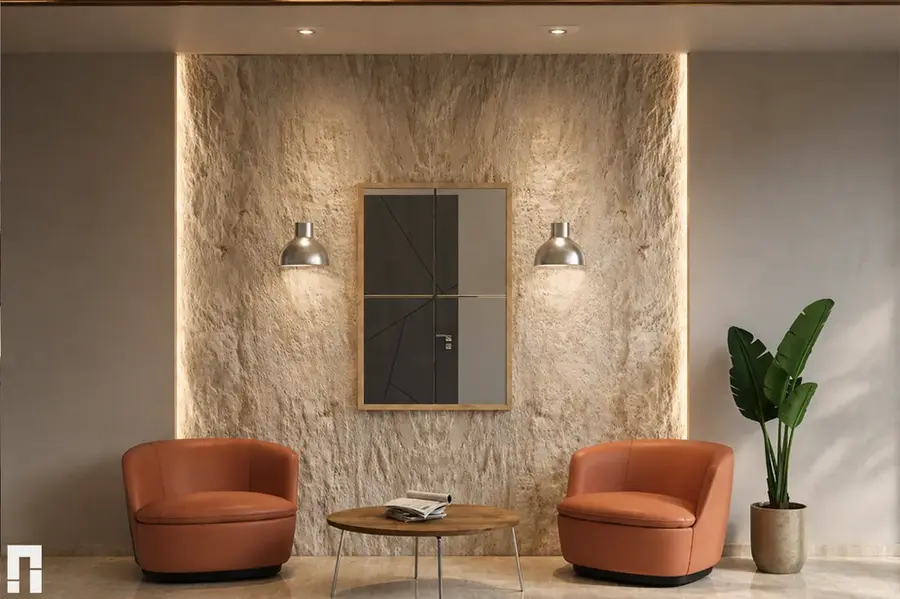 Residential lobby seating area on Charents Street in Yerevan with textured stone wall, soft lighting, orange lounge chairs, wooden table and indoor plant.
