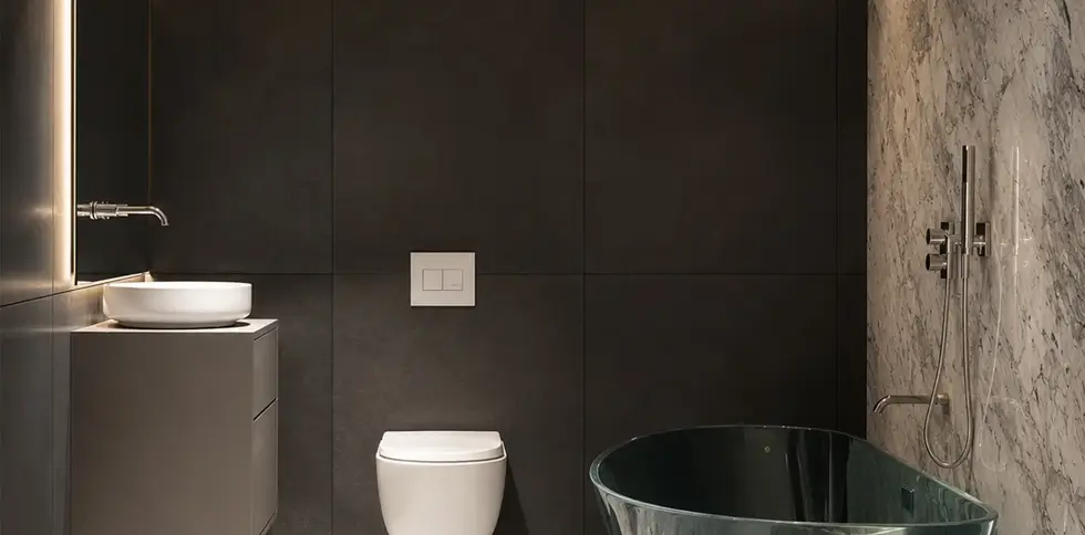 Luxury bathroom at Sose 25 residential project in Yerevan, featuring marble flooring, dark stone-look wall tiles, modern vanity, glass bathtub and rainfall shower.