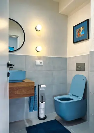Completed bathroom renovation with modern blue fixtures.
