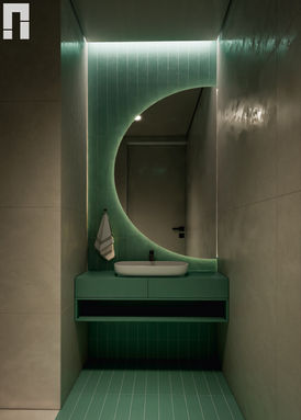 Modern bathroom interior with green tiles, round illuminated mirror, floating vanity, and ambient lighting
