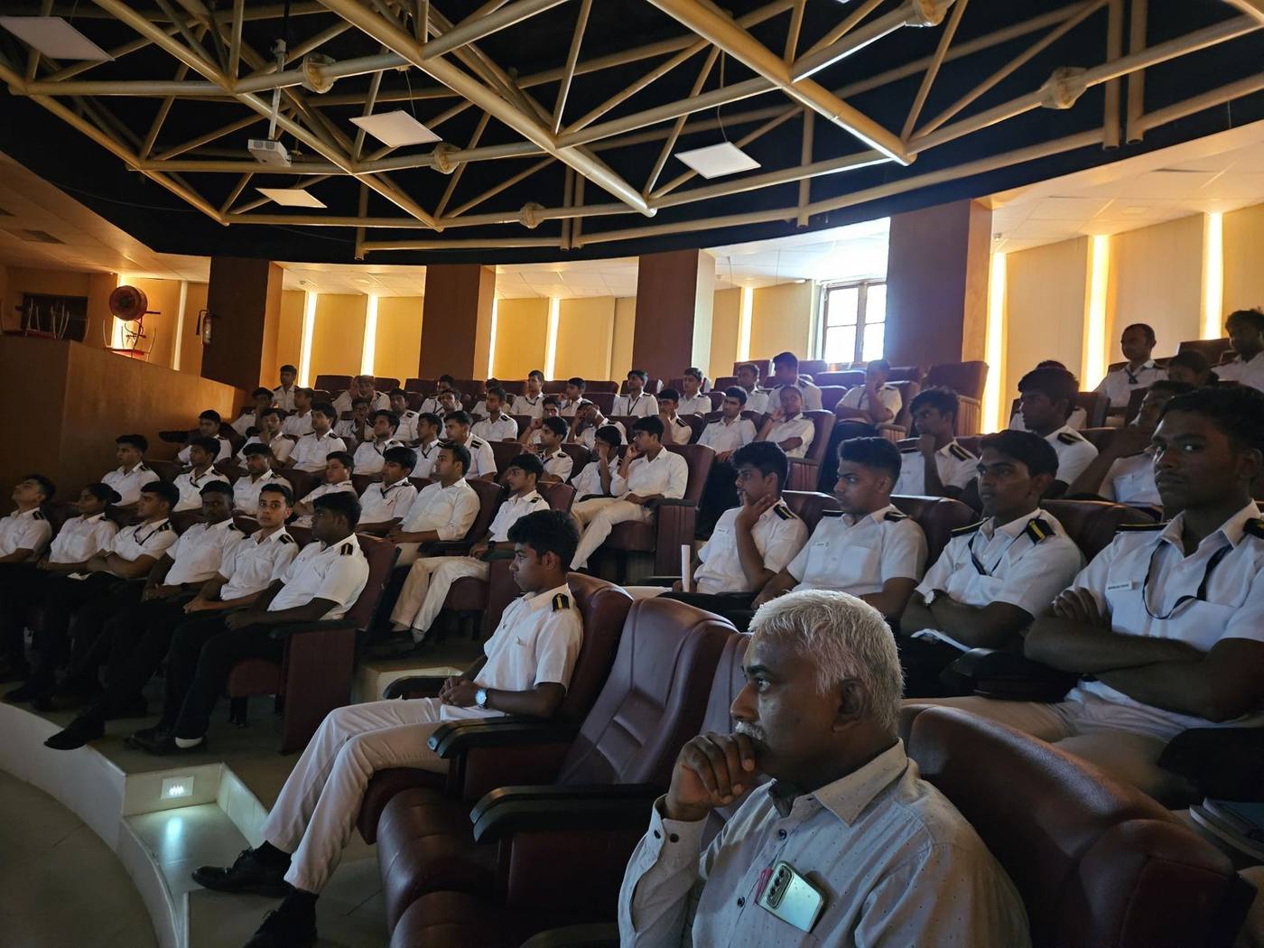 Cadetes de IMU de uniforme escuchan la conferencia en el auditorio