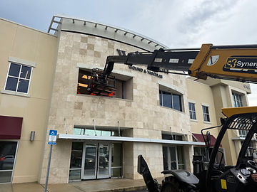 All Pro Rigging is moving medical equipment through a window in a second story