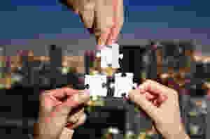 Der Beitrag heißt: "Betriebskatalyse lernen heißt Lernen lernen". Das Bild zeigt drei Hände vor einer Skyline, die jeweils ein Puzzleteil halten."
