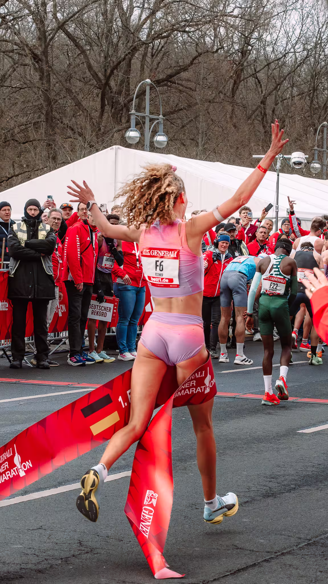 Female runner celebrating a German record at the finish line of the Berlin Half Marathon 2026.
