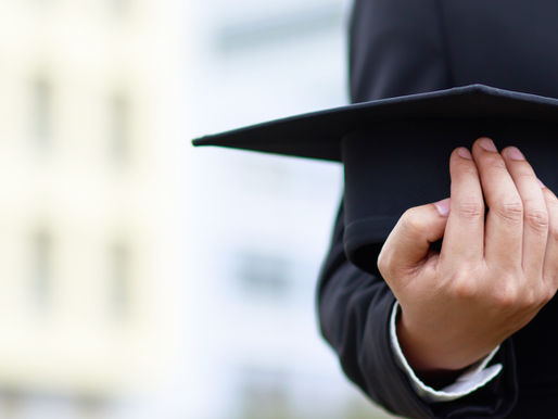Graduate holding a mortarboard cap in front of a university building, symbolising international students applying for the UK Student Visa