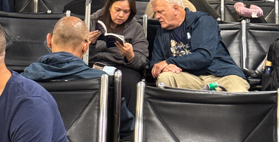 Harry speaks with a traveler about the gospel in the airport.