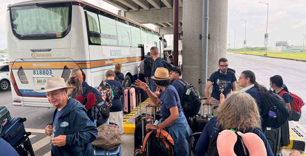 Missionary Froi Medina greets team members beside the bus as luggage is loaded.