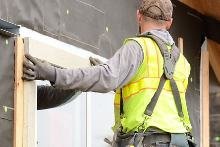 Worker installing trim around a window p