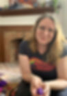 Helen, an AuDHDer and founder of Divergent Path Wellness, sits by a basket of fidget toys in their office. They smile gently while holding a small ball of purple playdough.