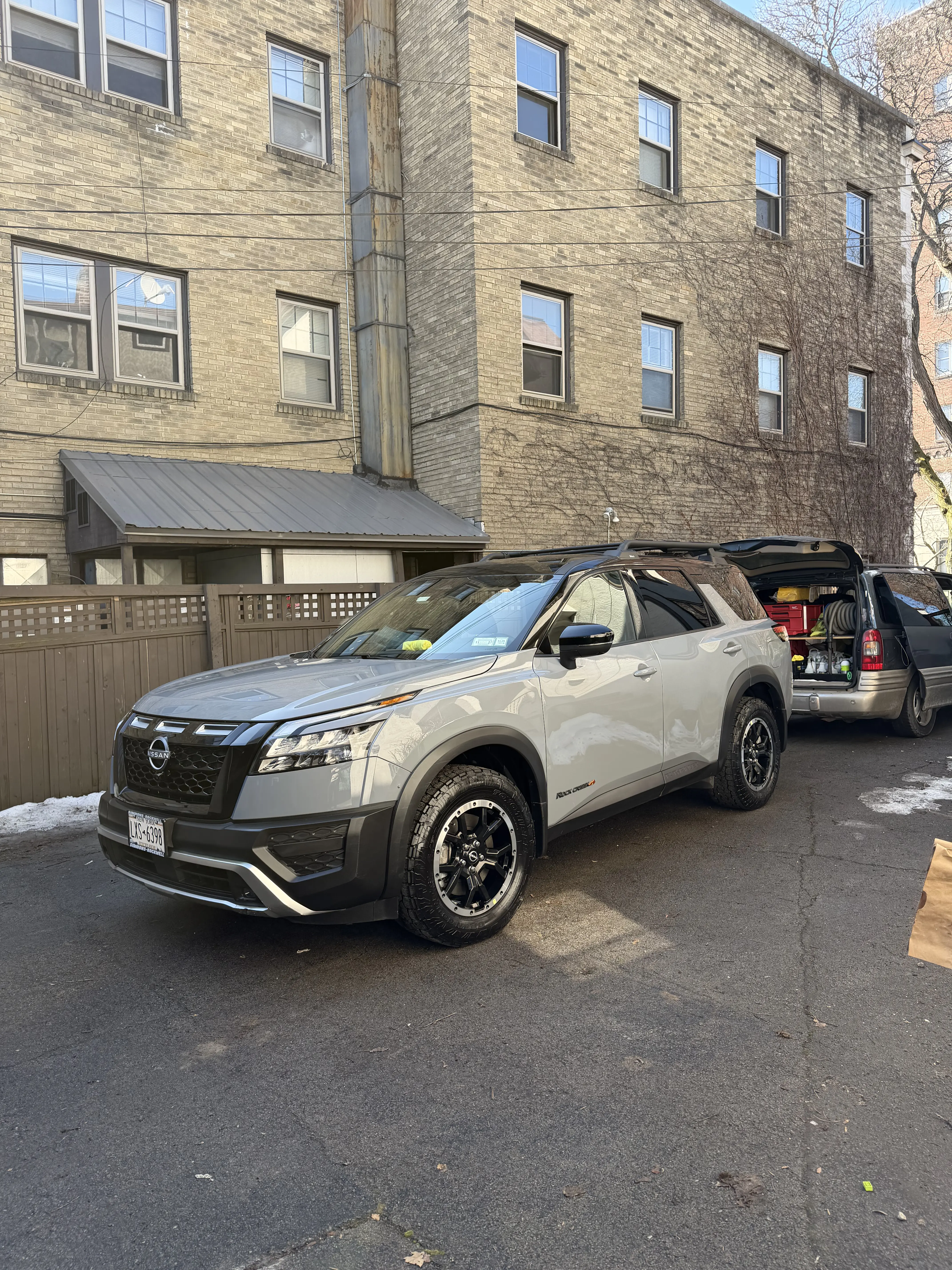 Clean and shiny gray Nissan Pathfinder SUV parked outside after a professional mobile exterior wash, detailing, and wax service in Rochester NY.