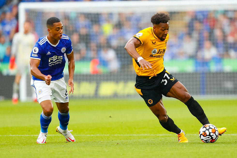 Two soccer players on the field; one in blue, one in yellow, competing for the ball. Blurred stadium background, dynamic action.