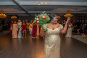 Cliffbreakers bride in gold dress tossing bouquet on dancefloor