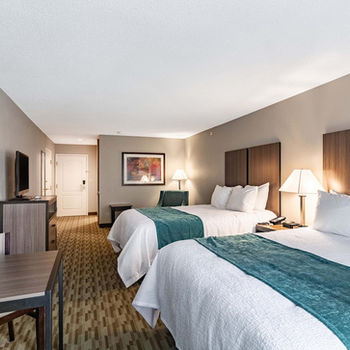 Riverview Inn and Suites guestroom with two queen beds, TV, and desk