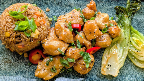 Close-up of a plate of Oak and Embers glazed, fried cauliflower pieces with a side of fried rice