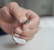 Grandfather cleaning his hearing aids so he can listen..jpg