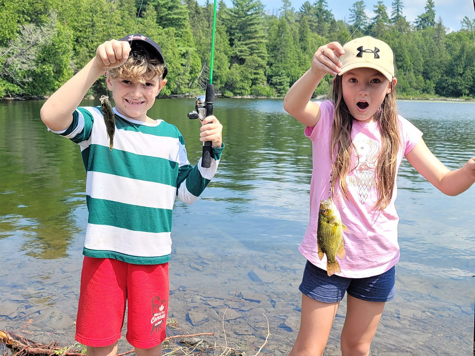 a boy and a girl holding up the fish they caught
