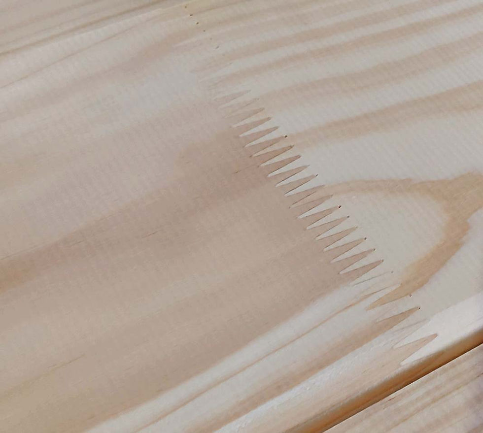 Close-up of a high-precision MTO finger-joint on a pine plank, manufactured for maximum structural stability and strength.
