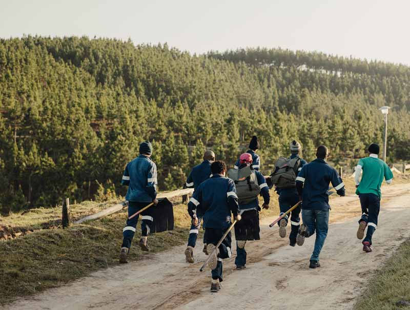 Team running with firefighting equipment during a timed competition event