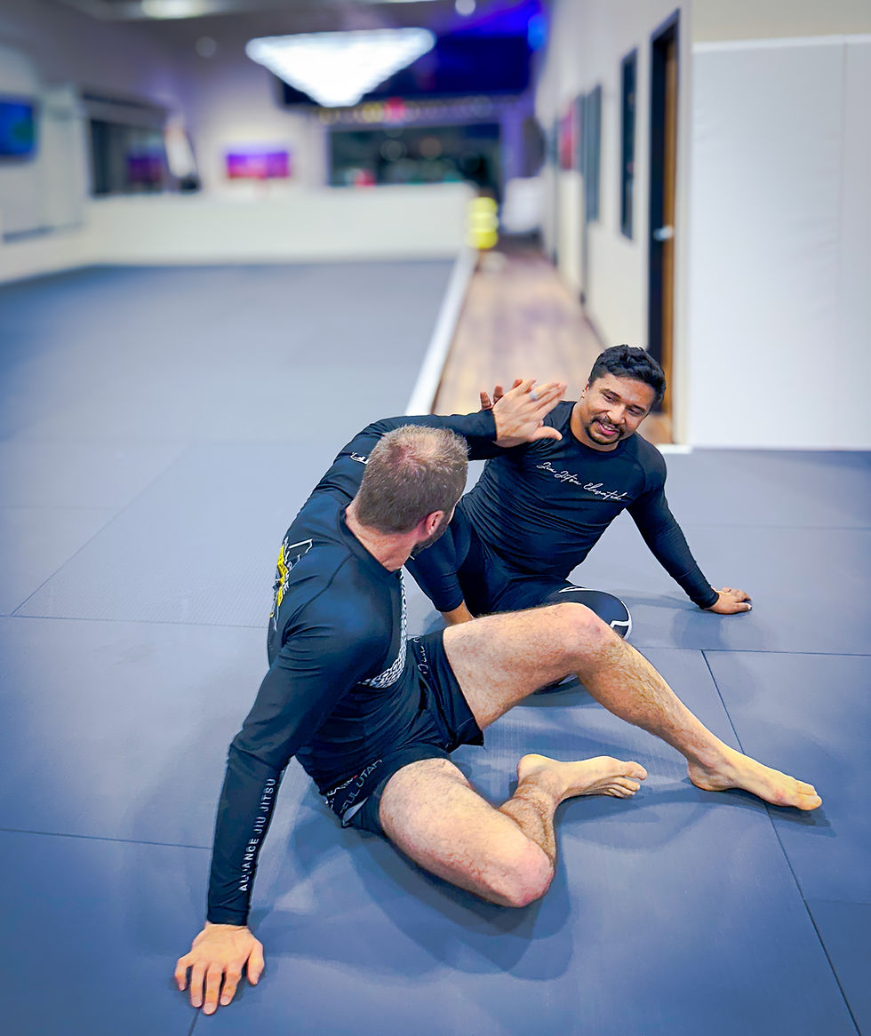 Two Alliance Jiu Jitsu athletes training together at Alliance Jiu Jitsu Bountiful in Utah, practicing technique during a structured class led by black belt professors.