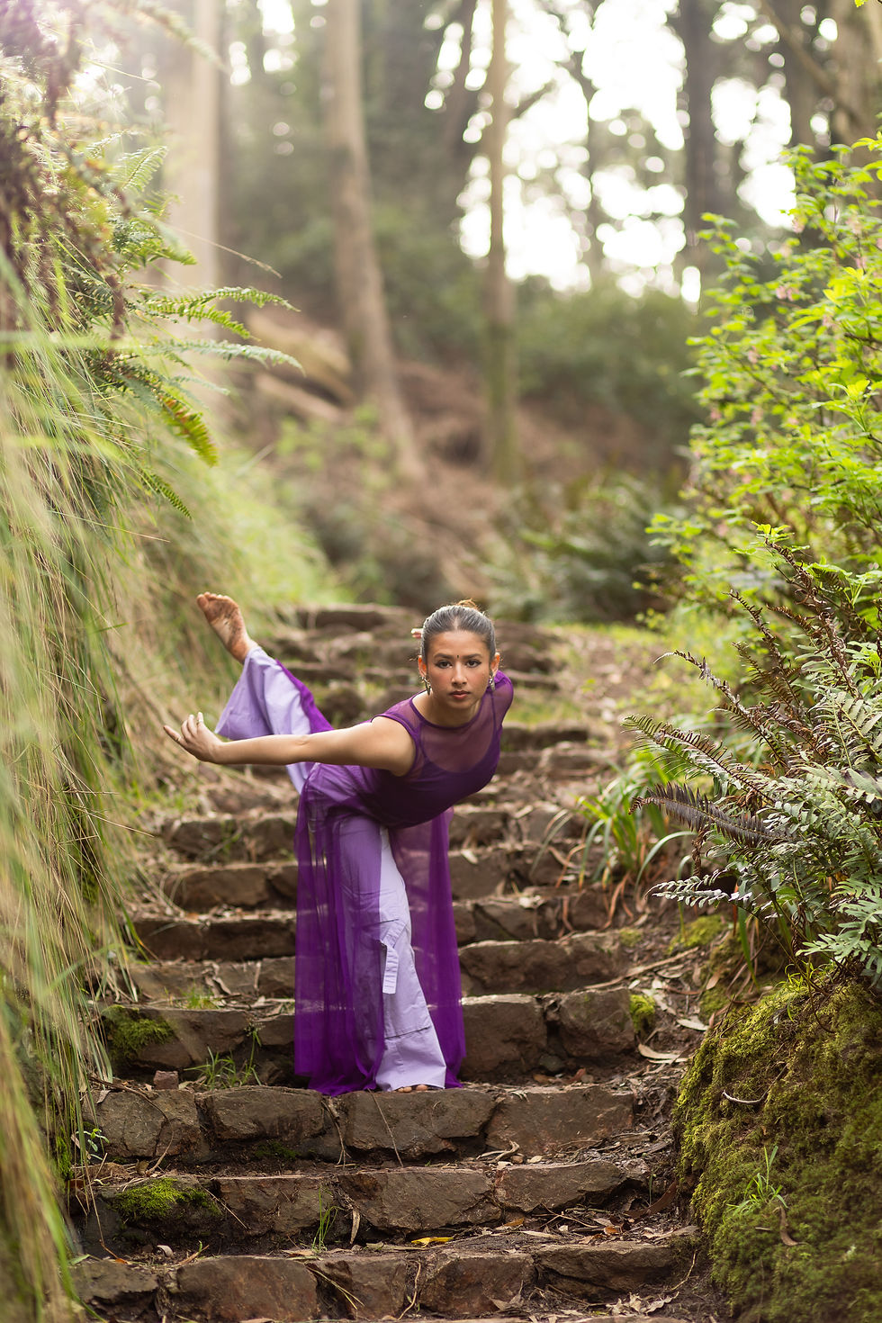 Mili poses before me, backlit by the soft sun, surrounded by lush ferns and ivy - a photographer's dream. I switched to my 85mm for this.