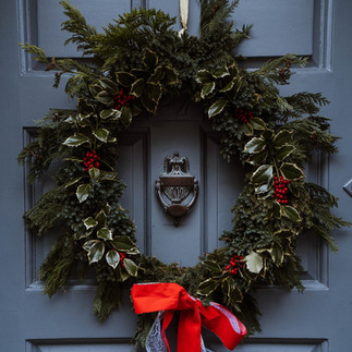 різдвяний вінок на двері зі стрічкою з гілочками трілістника