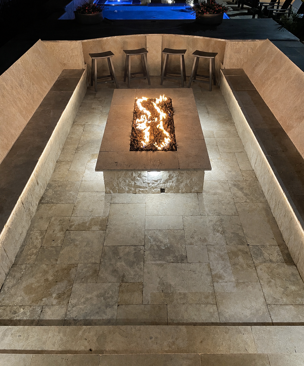 Custom travertine outdoor entertaining area with built-in linear gas fire pit and integrated seating - luxury fire pit instal