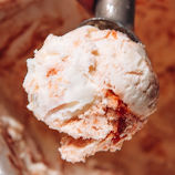 close-up of cream cheese ice cream with swirls of guava and chunks of puff pastry