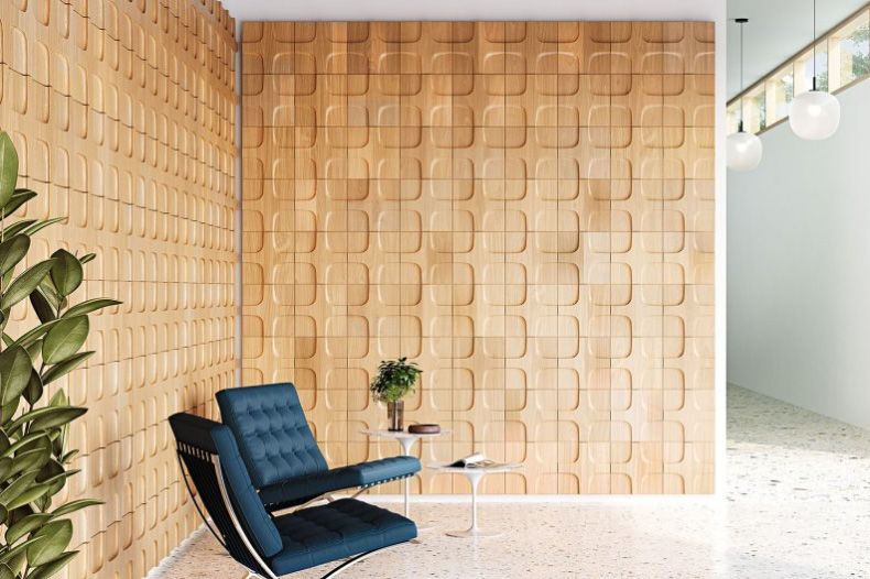 現代客廳內一張藍色椅子,旁邊有白色小桌,桌上放著植物。背景是木紋立體牆,氣氛簡約舒適。