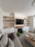 Living room with built-in carpentry shelves, cabinets, and TV