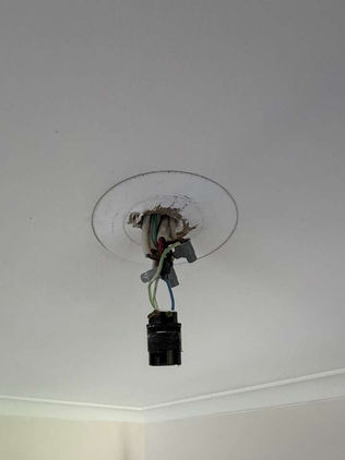 Old batten holder with exposed wiring before a lighting upgrade in a Canberra home