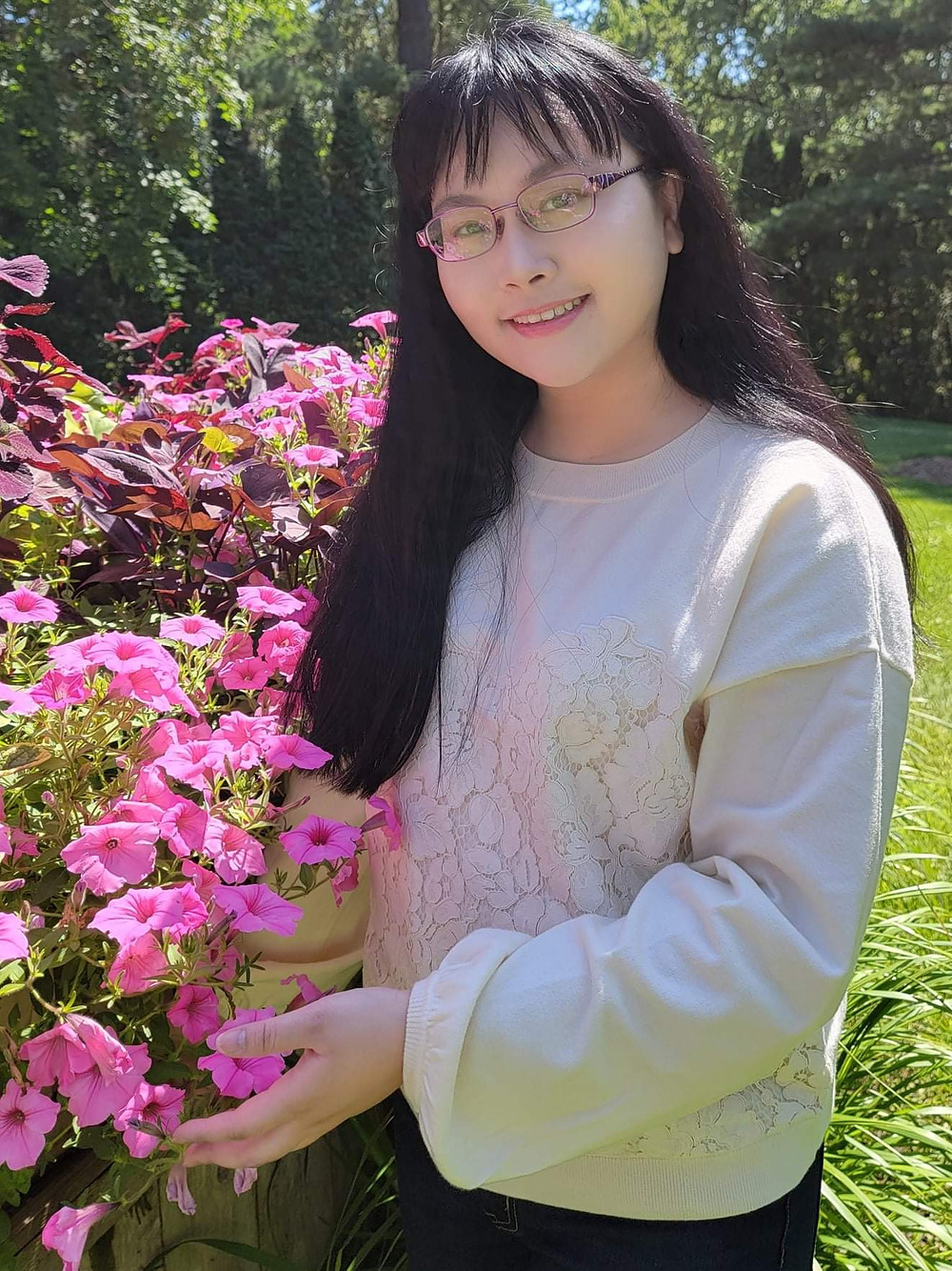 A woman standing next to pink flowers
