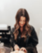 Photograph of Kate working on a client's eyebrows and lashes in her studio.