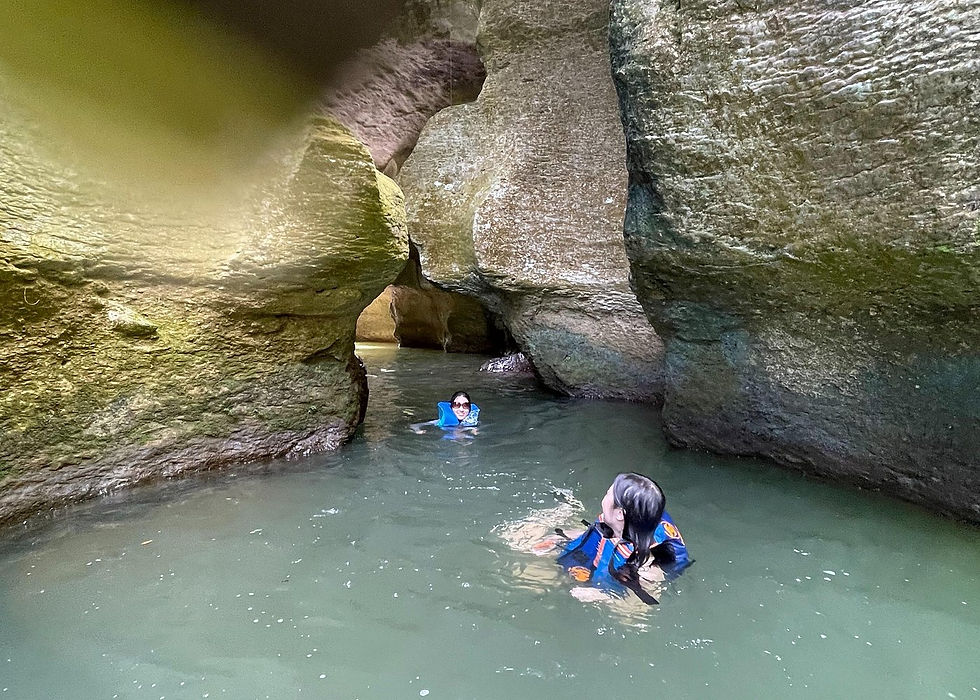Travelers swimming through rock formations and caves at Charco Azul in Puerto Rico.