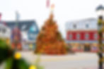 Festive town square with a large, decorated Christmas tree. Surrounding colorful buildings; joyful holiday atmosphere.街,无停车。