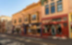 Tourists take a technicolor stroll down Bisbee's Tombstone Canyon, the town's main street. This brightly colored row of historic buildings is typical of the town's vibe.