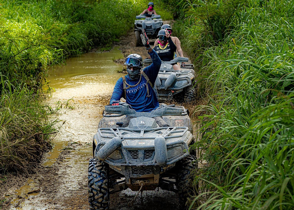 Group riding ATVs through muddy trails at Hacienda Campo Rico in Puerto Rico.