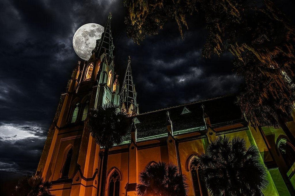 Gothic church lit orange and green under a full moon in a stormy night sky, framed by palm trees.